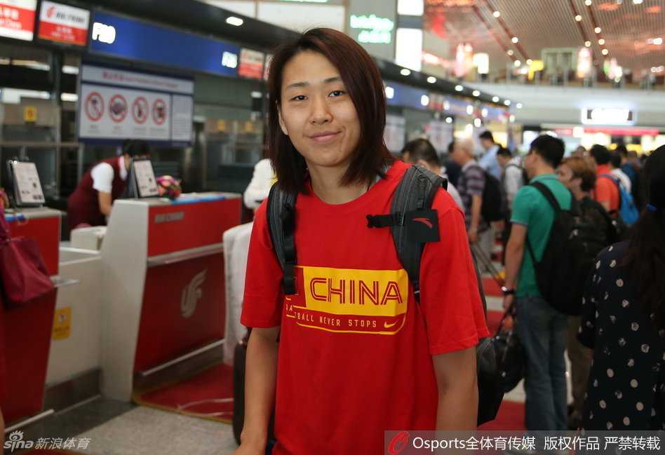 黄思静小心翼翼地将吉祥物维尼修斯捧在胸前，这个造型独特的黄色小精灵象征着巴西的热情与活力，此刻它正安静地陪伴着女篮姑娘们一同飞向里约。