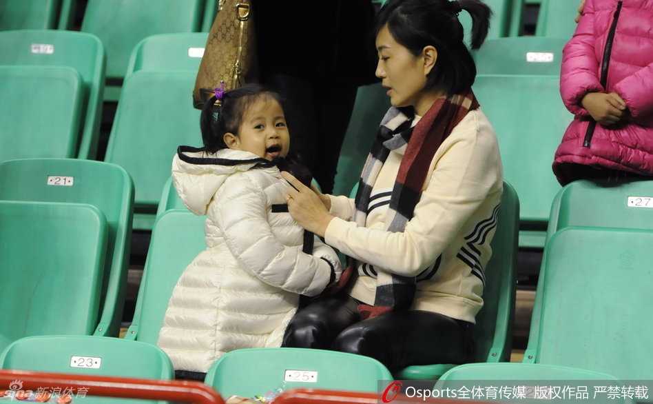 郭士强怀抱女儿穿过球场，女儿侧身回望，小手轻轻指向远方，郭士强脸上露出一丝不易察觉的慈父微笑