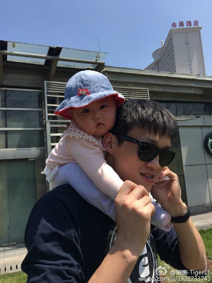 周鹏熟练地推着婴儿车带女儿散步，小公主舒服地躺在车里，好奇地张望着这个新奇的世界，而爸爸就是她最安全的领航员。