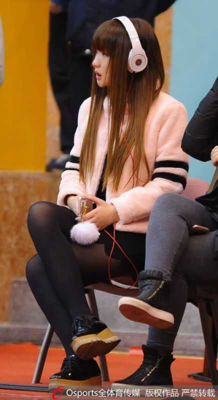 在空旷的雅戈尔体育馆内，女球迷独自坐在她固定的座位上，目光柔和地望向球场，仿佛在回味往昔的精彩瞬间。