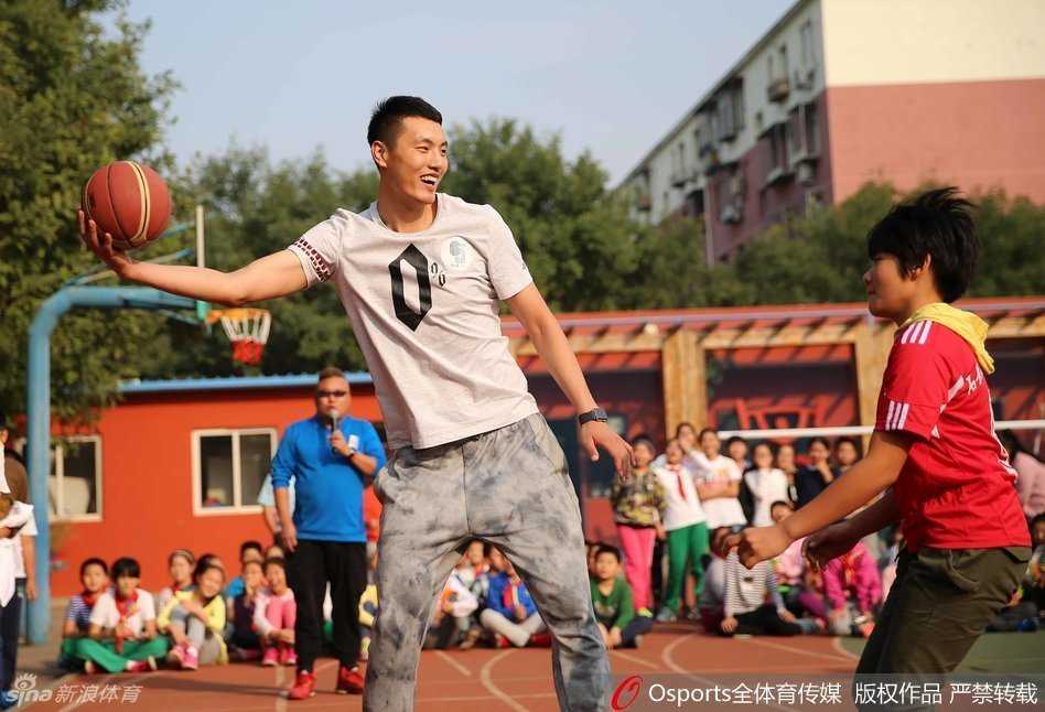 翟晓川被热情的孩子们团团围住，他弯腰俯身为小朋友签名，脸上带着亲切的笑容，孩子们踮起脚尖眼神充满崇拜