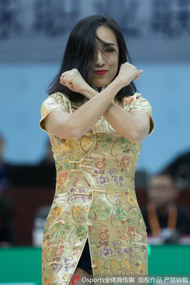 特写镜头捕捉到一位舞者完成高难度下腰动作的瞬间，她眼神坚定地注视着前方，脸上的亮片在灯光下闪烁着迷人的光芒。