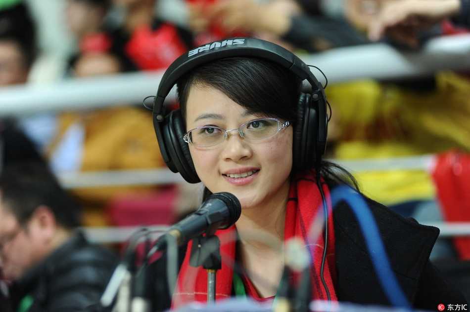 她低头看着手中的资料，场内明亮的灯光在她脸上投下柔和光影，这一刻的安静与球场的喧嚣形成奇妙对比