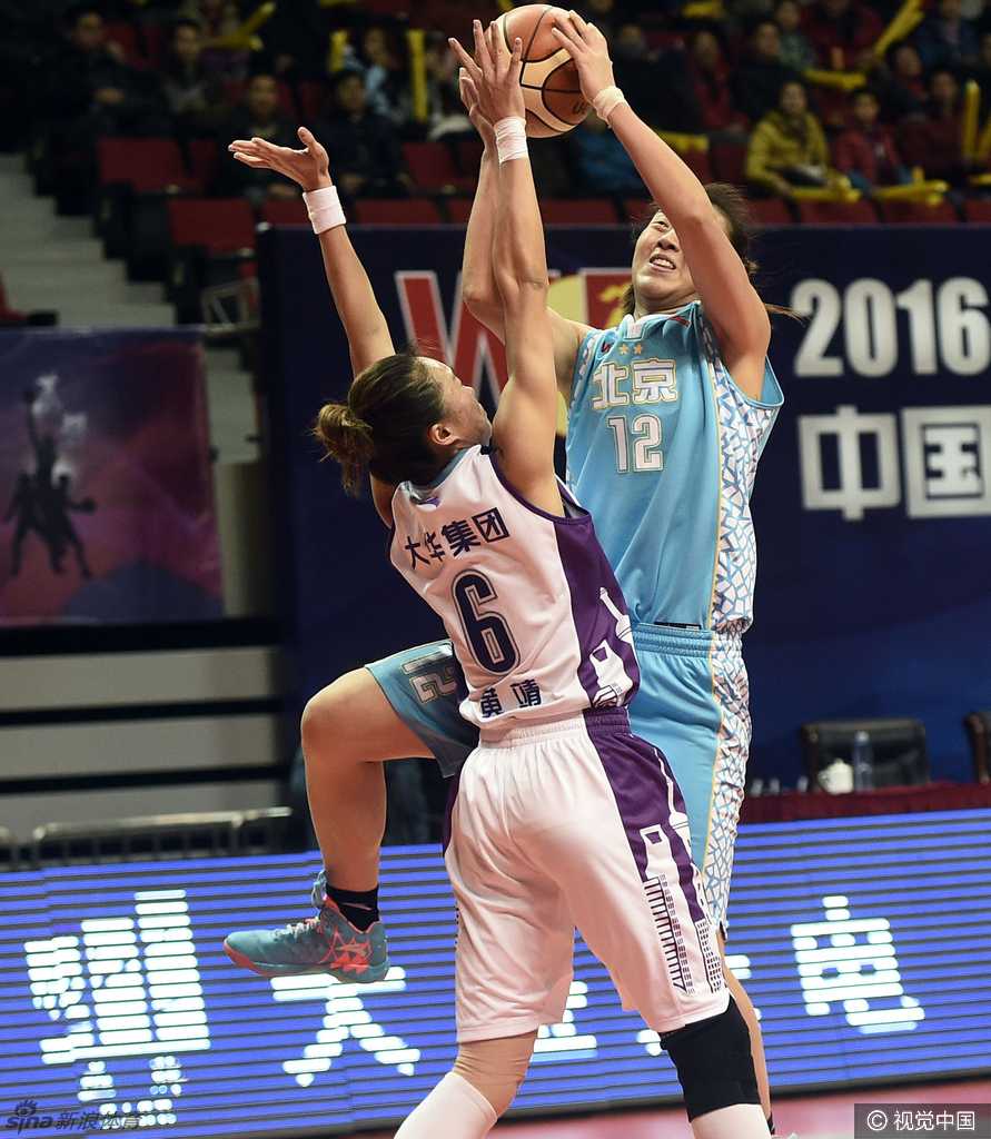 终场哨响，上海宝山大华女篮的球员们在中圈激动地拥抱在一起，庆祝这场来之不易的主场胜利，背景是大屏幕上醒目的70-62比分