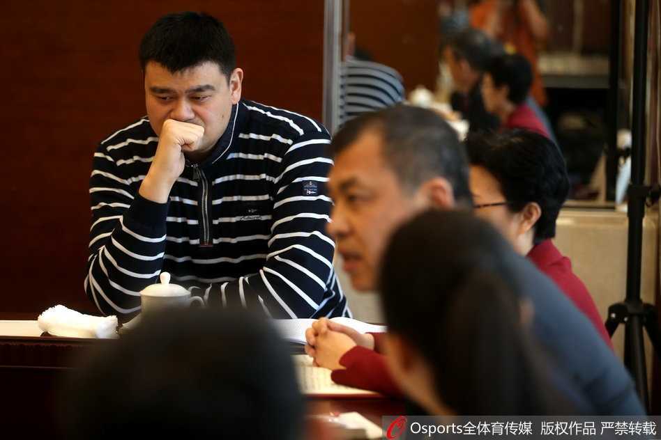 身高2米26的姚明在人民大会堂东门外台阶上被层层记者包围，他面带微笑，从容地俯身倾听身前记者的问题，巨大的身高差让这场采访显得别有趣致。