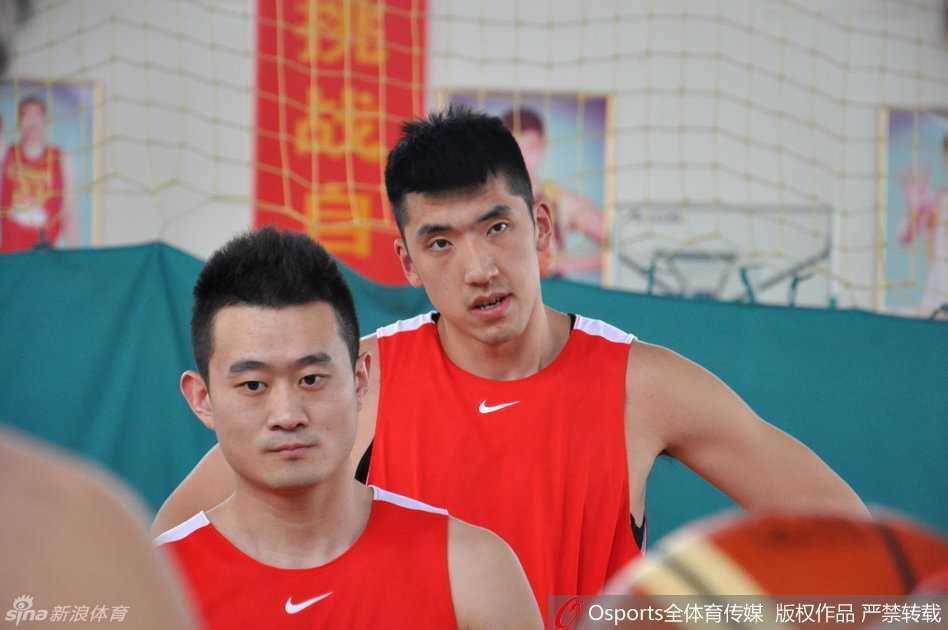 丁彦雨航在对抗训练中强行突破上篮，身体在空中舒展如满弓，眼神死死盯着篮筐，防守球员无奈只能犯规。