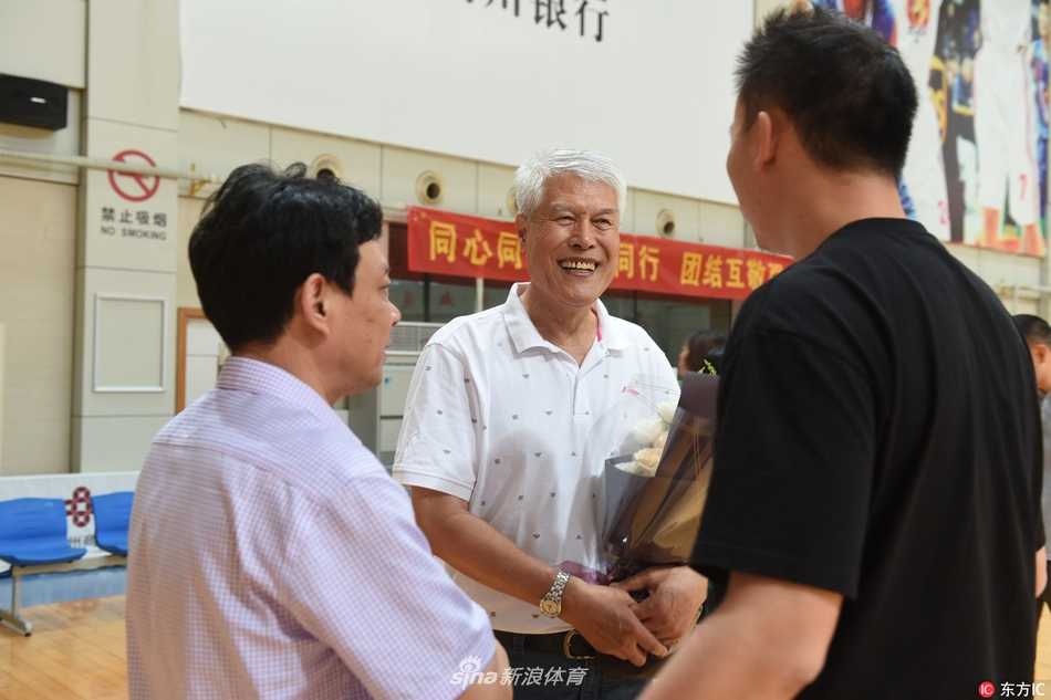 精神矍铄的蒋兴权指导身着简洁衬衫，步伐稳健地走出义乌车站，目光深邃地望向迎接的人群，开启了新的篮球征程。