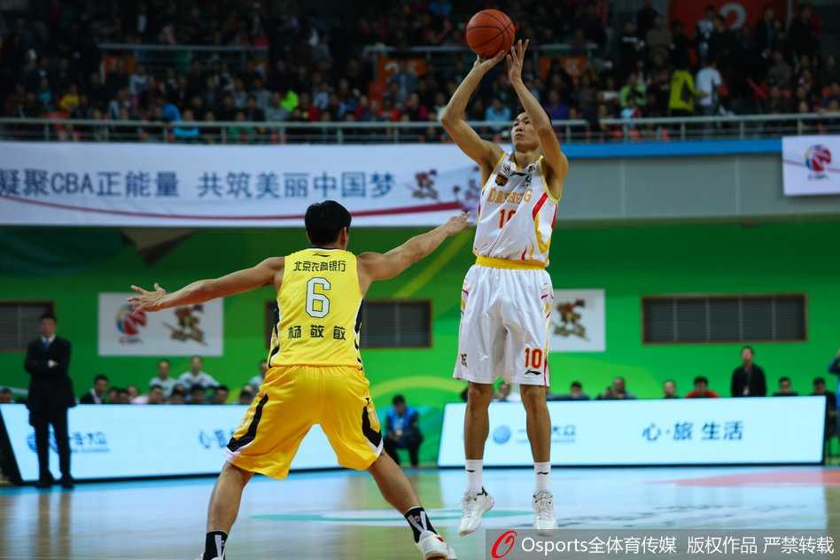 多米尼克-琼斯如闪电般撕裂北控防线，他高高跃起，眼神坚毅，手中的篮球仿佛黏在指尖，面对两人包夹依然从容不迫，准备完成一次关键的传球。