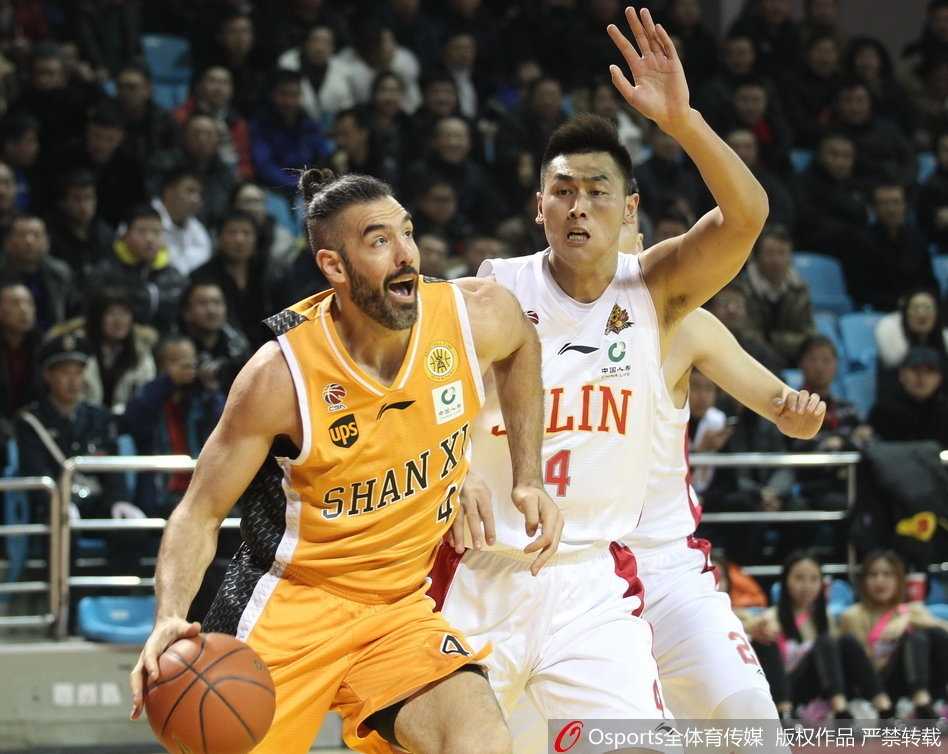 山西队球员曾令旭在运球突破时遭遇吉林队两人包夹防守，他冷静地护住球，寻找队友的跑位空当