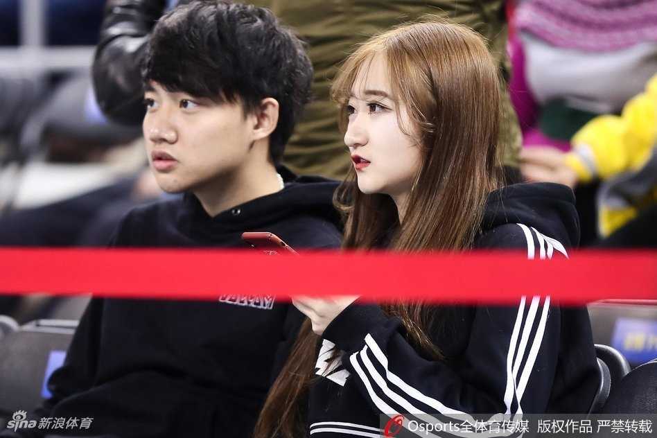 身穿厚实冬装的姑娘站在场边通道，她竖起大拇指为场上的将士点赞，背景是巨大的北京男篮队徽，这一刻，她不是在追星，而是在守护这座城市的荣耀。