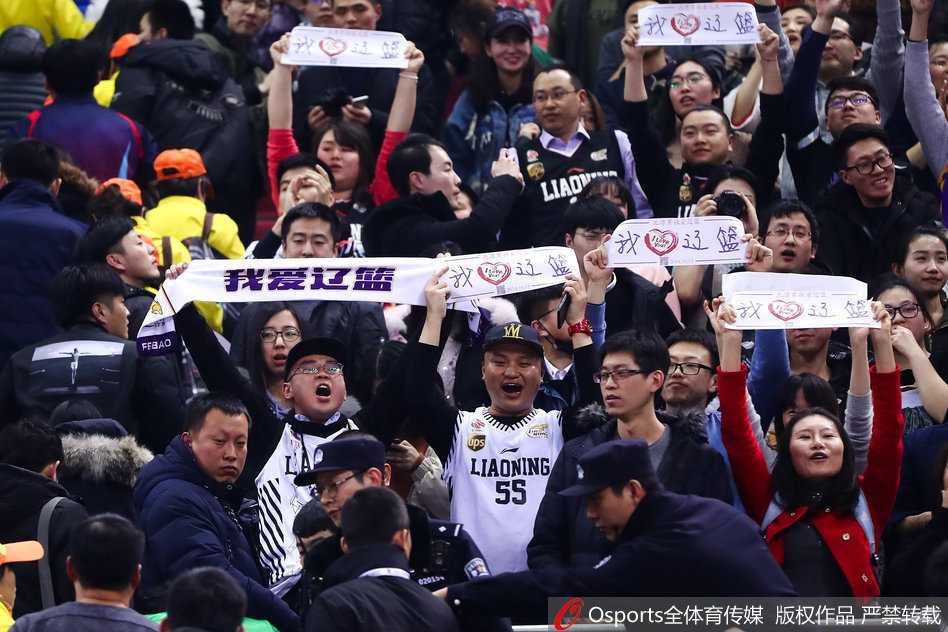 身着白色助威服的辽宁球迷方阵在五棵松体育馆内齐刷刷地起立，他们挥舞着手臂，眼神中充满期待，仿佛要将客场变成自己的主场