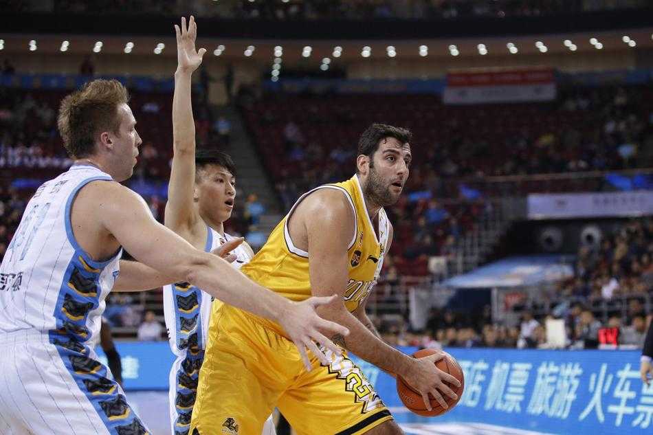 广厦队胡金秋在低位持球，背身单打防守球员，他利用灵活的脚步转身跳投，篮球划出一道优美的弧线坠入网窝。