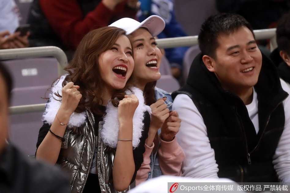 扎着丸子头的俏皮女球迷，表情略带嗔怪，嘟着嘴看向赛场，流露出对球队表现既失望又难舍的复杂情感。