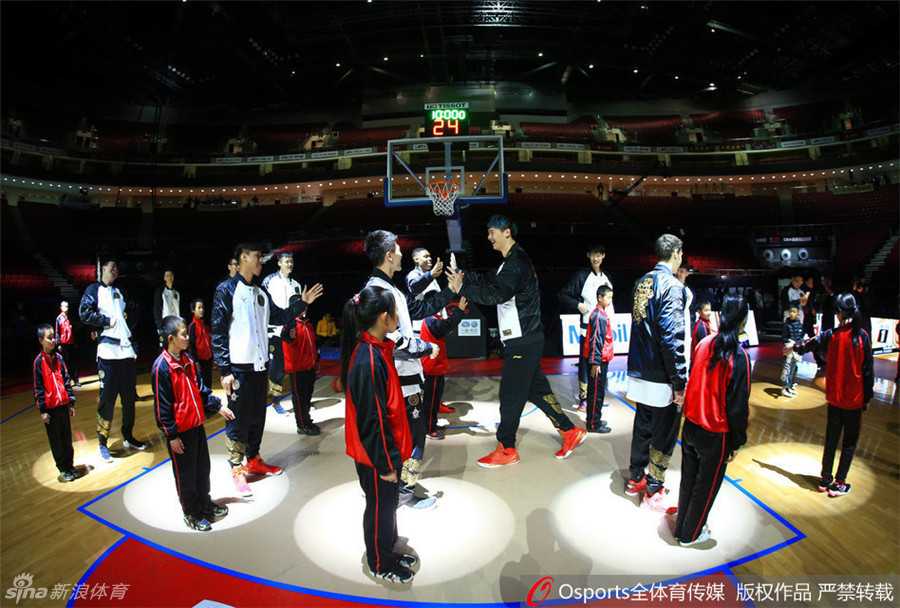 彩排间隙，工作人员递上篮球，球员在灯光下顺手进行投篮热身，篮球在空中旋转，定格了赛前这轻松而专注的一刻。