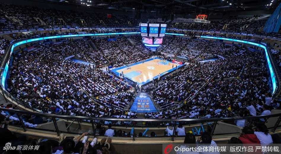 北控外援在严密防守下强行突破，他神情坚毅，肌肉线条分明，与首钢防守球员的手臂交织在一起，力量与对抗感溢出画面。