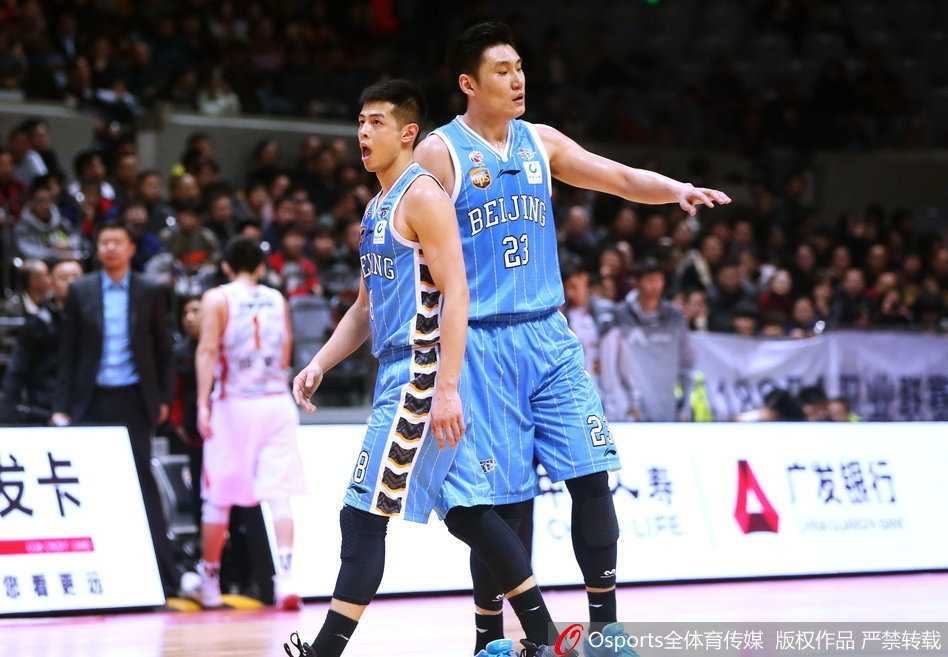 北京队外援面对防守球员的长臂干扰，依然跳起传球，皮球划出一道弧线飞向底角的空位队友，指挥若定的神情彰显核心本色。