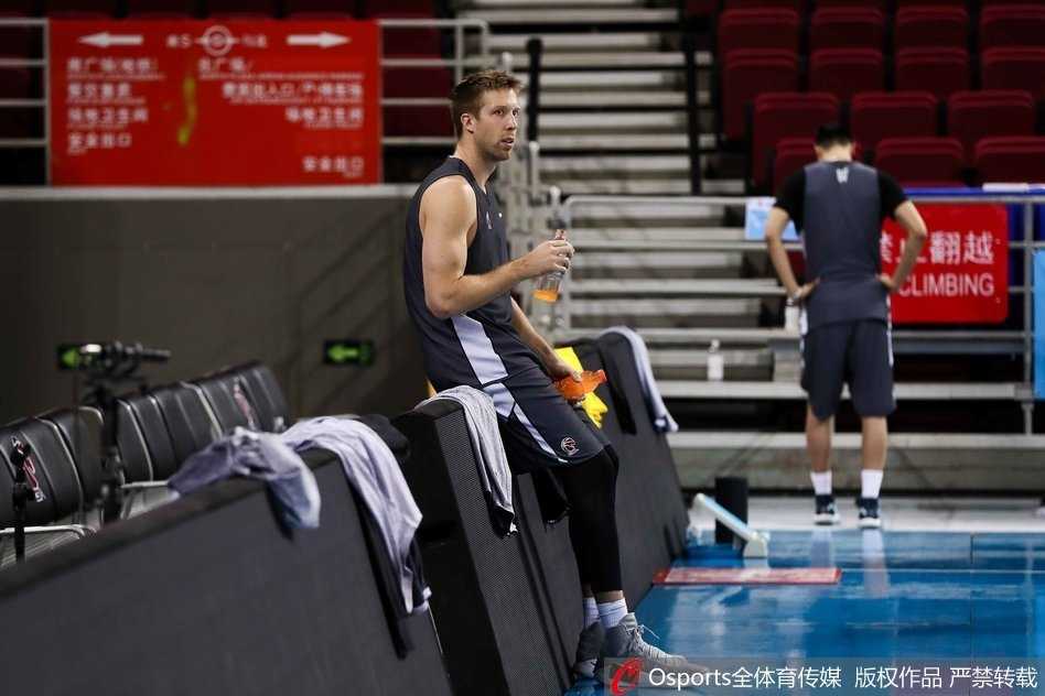 训练结束后，刘晓宇与队友常林并肩走向场边，两人边走边聊，脸上洋溢着轻松的笑容，身后的看台空旷寂静，映衬出兄弟情谊的温暖。