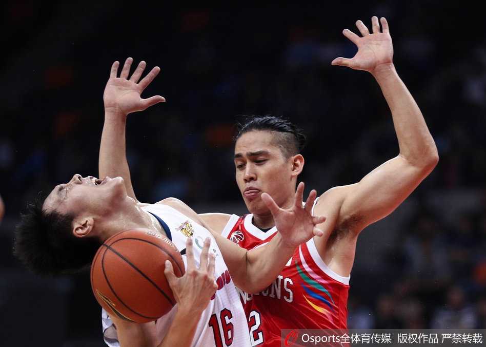 辽宁队中锋韩德君在山东队内线拼抢下前场篮板，落地瞬间肌肉紧绷，眼神坚毅如铁，展现出本土魔兽的霸气