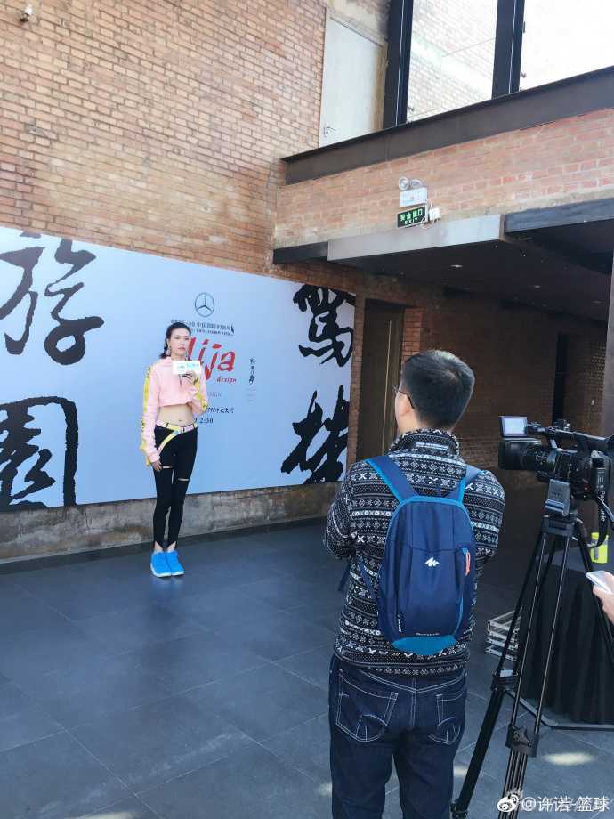 全景镜头下的许诺与豪车，她双手自然垂落，从容自信的气场全开，完美融合了运动员的挺拔与女性的柔美。