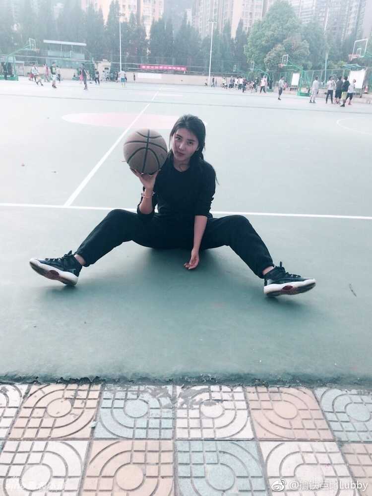 糖糖穿着简约的白色背心和黑色短裤，露出健康的小麦色肌肤和马甲线，对着镜头比出胜利的手势笑容灿烂