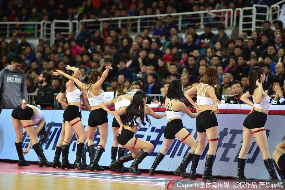 身披金色流苏战衣的啦啦队长发丝飞扬，她回眸的瞬间，眼眸中映出场馆的灯光，自信的笑容仿佛能穿透屏幕，感染力十足。