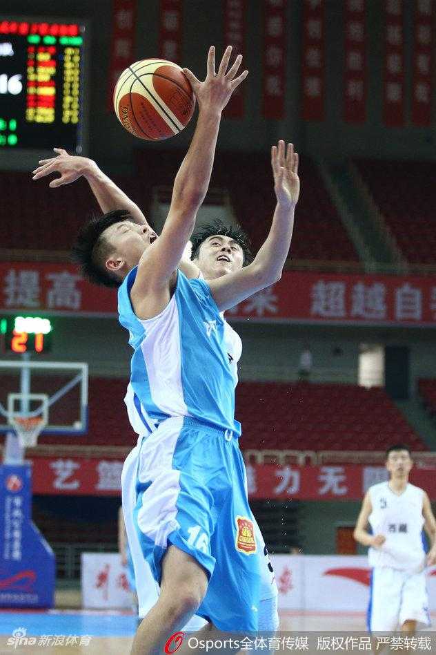 西藏队内线球员奋力跃起，试图封盖河南队的投篮，防守决心坚如磐石