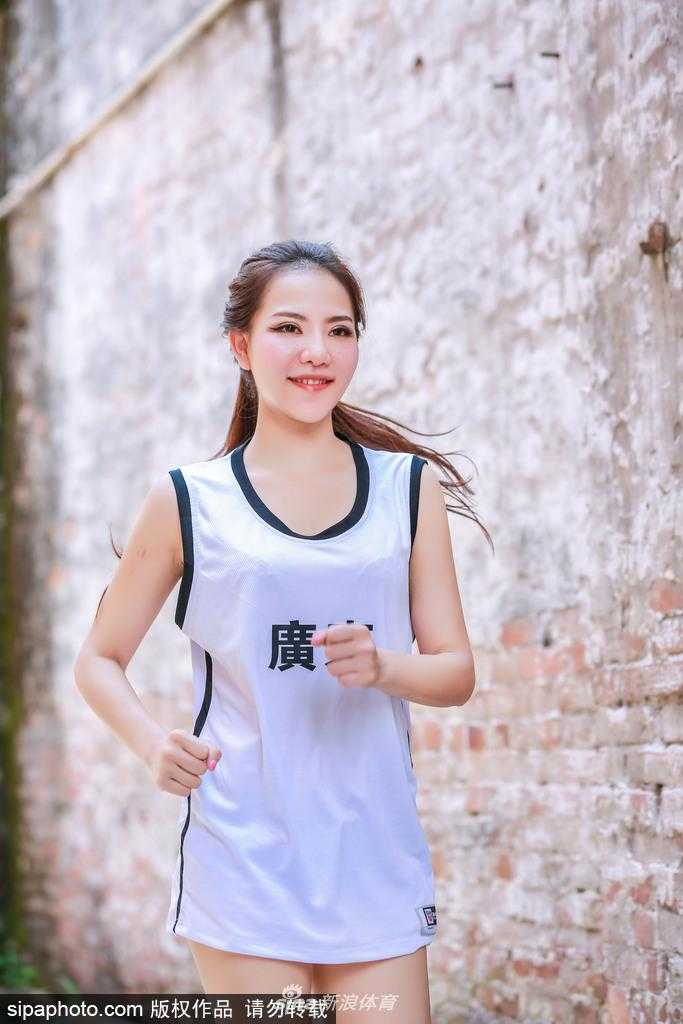 写真拍摄中，一位宝贝轻抚发丝，举手投足间流露出独特的东方韵味，与激烈的篮球赛场形成一道和谐的风景。