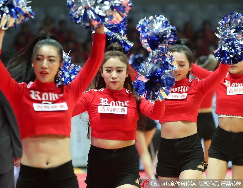 一名小宝贝拿着比自己小脸还大的迷你篮球，模仿着场上运动员的动作准备投篮，样子十分俏皮可爱