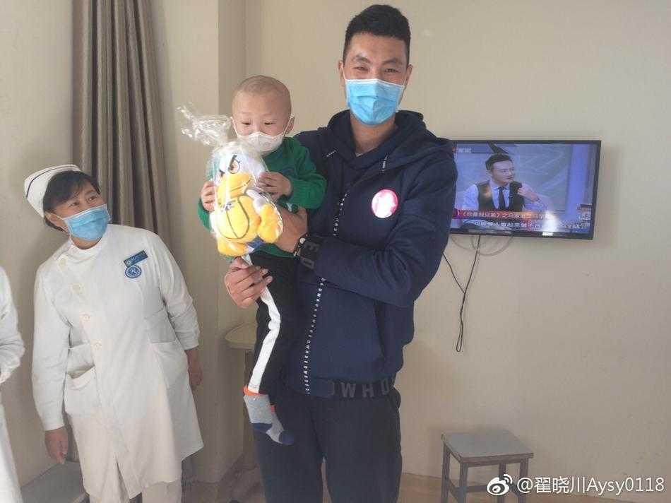 病房的活动区内，翟晓川和队友张松涛陪伴在孩子们身边，大家围坐在小桌子旁，聚精会神地拿着画笔在画纸上涂抹色彩，共同创作他们心中的篮球梦想。