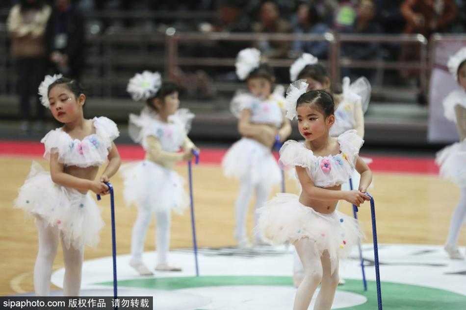 舞蹈进行到高潮，宝贝们将拐棍高高举起，脸上绽放出灿烂自信的笑容，整个球场都沉浸在她们营造的欢乐氛围中。