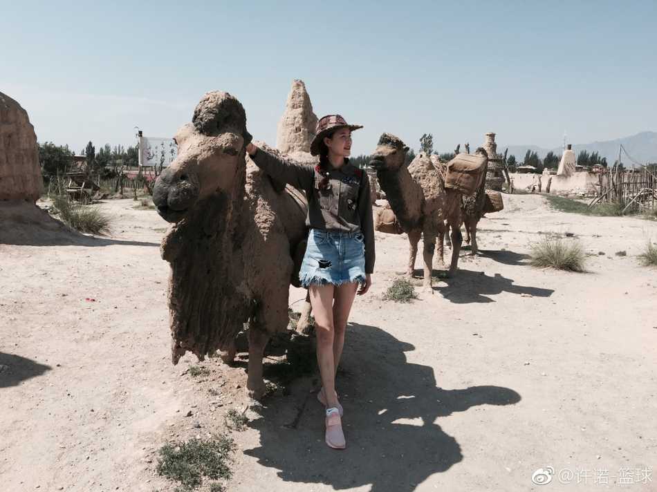 在电影《大话西游》的经典取景地前，许诺扎起马尾，身着黑色T恤和短裤，一条腿俏皮地微微弯曲，仿佛在与银幕中的故事对话，既有江湖儿女的豪气，又不失女孩子的俏皮。