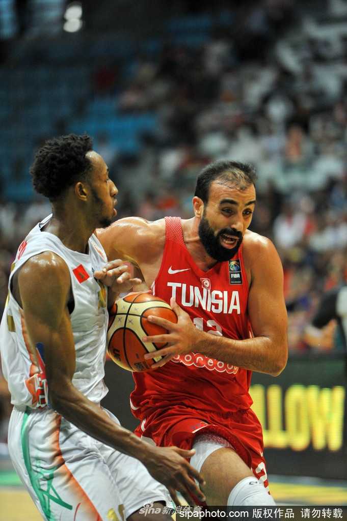 摩洛哥球员赛后神情落寞地站在场边，汗水浸湿了球衣，眼神中充满了不甘与失落