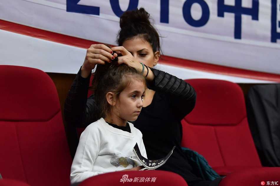 博洛西斯在妻女的注视下显得格外兴奋，他张开手臂试图干扰广东队的传球路线，脸上写满了专注与对胜利的渴望。