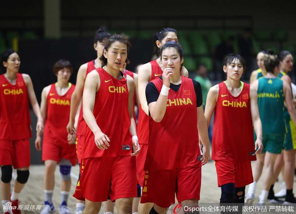 内线球员李梦在对抗训练后喘着粗气，用手拉起球衣擦拭汗水，一旁的教练员正拿着战术板给她讲解刚刚的卡位动作。