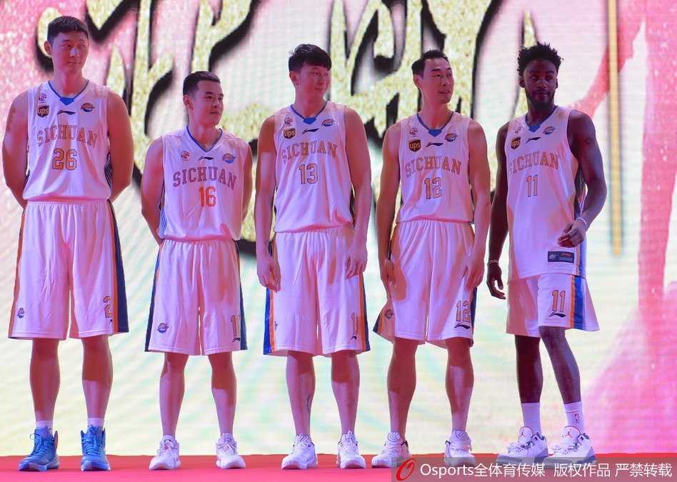 伊朗中锋哈达迪在发布会台上咧嘴大笑，他身着黄色T恤显得格外醒目，憨厚的神情仿佛对即将到来的新战役信心满满。