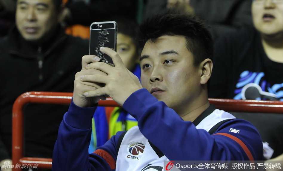刘国梁在场边露出标志性的笑容，身前的辽宁队标牌格外醒目，这一刻他不再是严厉的教练。