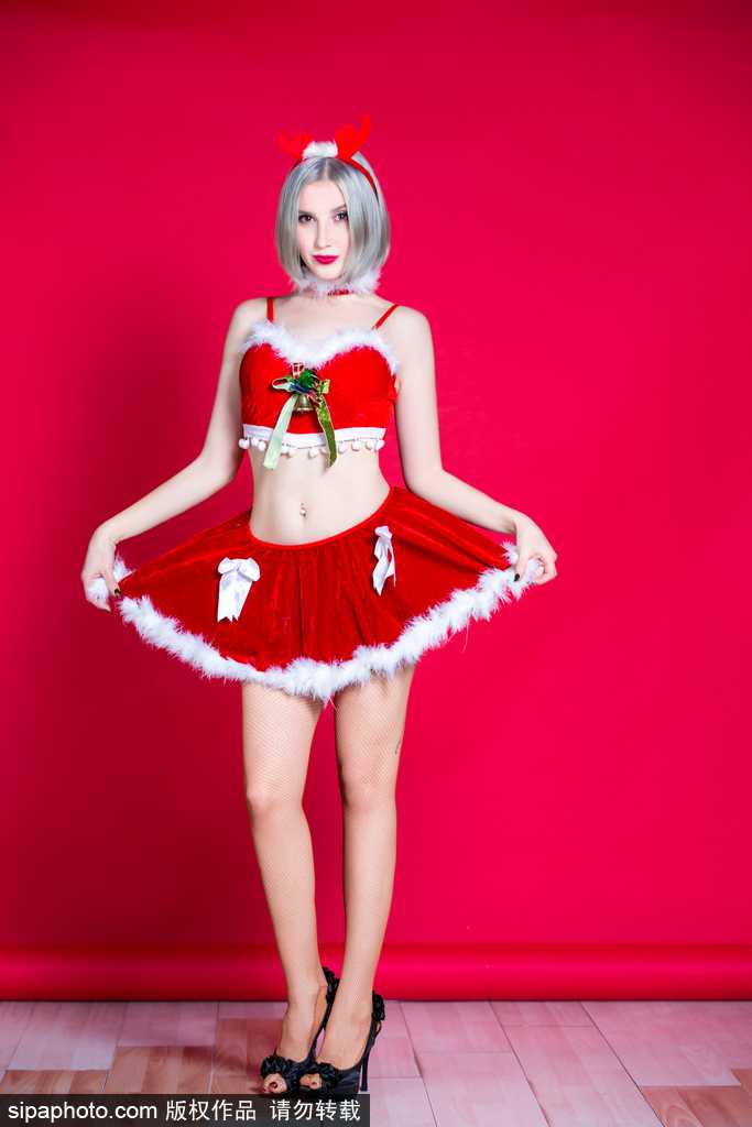 宝贝轻抚驯鹿玩偶，身姿曼妙，眼神中流露出孩童般的纯真与节日的俏皮，圣诞气息扑面而来。