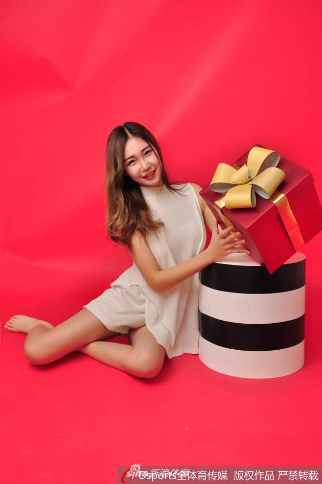 思凡手捧一个红色的圣诞礼盒，笑容比身后的圣诞树还要灿烂，充满治愈感。