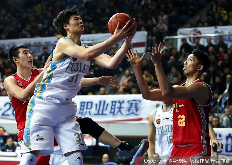 王哲林在八一队内线群中高高跃起，犹如擎天柱一般单臂完成势大力沉的劈扣，对手只能无奈仰望。