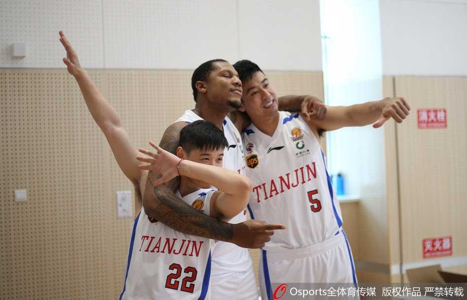 在一片蓝色的座椅背景前，队友们默契配合，在霍尔曼身后围成一圈，大家同时做出夸张的欢呼表情，仿佛在庆祝一场已经到手的胜利。