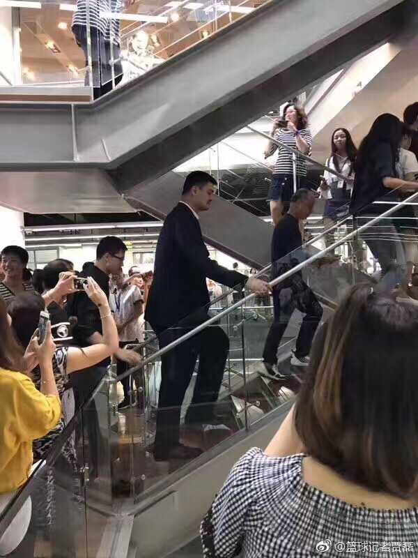 篮协主席姚明身着休闲装现身李宁园区，神情专注地与身边工作人员交流，身后巨大的李宁logo标志格外醒目，预示着双方即将开启的深度对话。