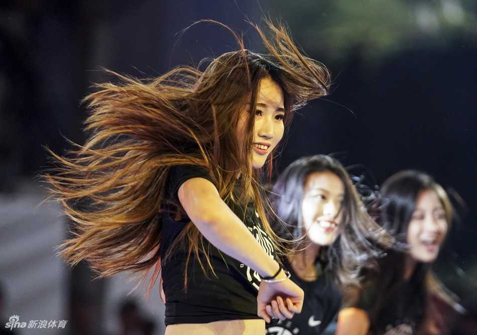 一名穿着白色球衣的年轻女篮球员在比赛中控球，她眼神犀利，表情专注，虽然身形不如男子球员高大，但运球的节奏和技巧却透露出不俗的实力。