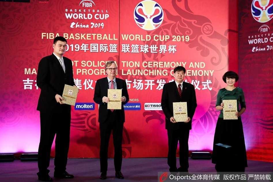 姚明身着深色西装正装，低头仔细审视手中的文件，眉宇间透露出一丝严谨与认真，身后的背景板印有篮球世界杯的官方标识，记录下这一历史性的签约时刻。