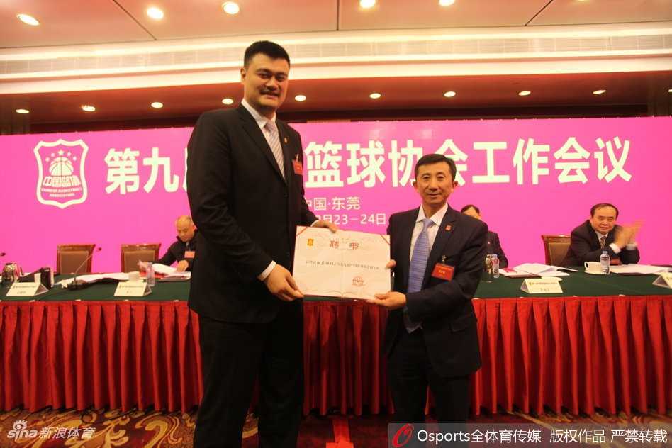 面对媒体的镜头，姚明在会后被团团围住，他从容不迫地回答着每一个问题，闪光灯映照出他那张既熟悉又充满坚毅神情的脸，仿佛在无声地传递着对未来的担当。