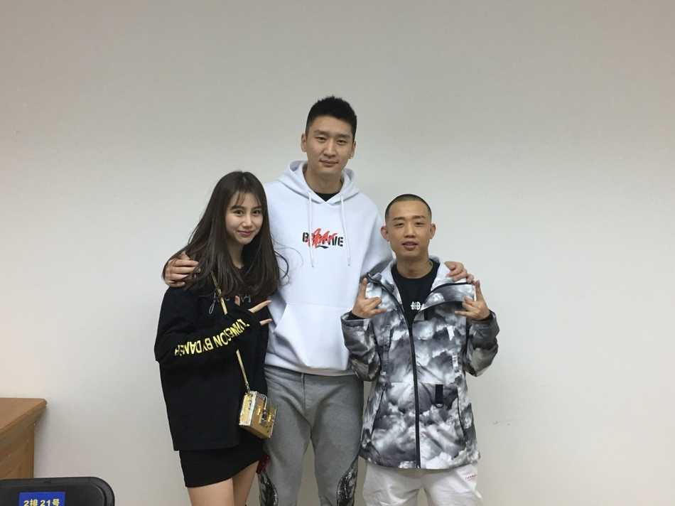 孙悦面带微笑与妻子陈露、GAI并肩站立，三人眼神默契，陈露的甜美笑容和GAI的标志性手势构成一幅和谐的跨界友谊画面。