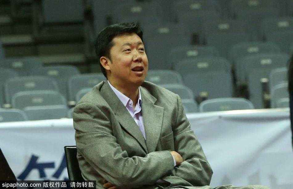 球场灯光映照下，王治郅的神情显得格外平静而专注，手中的战术板记录着他从球员到教练的智慧沉淀。