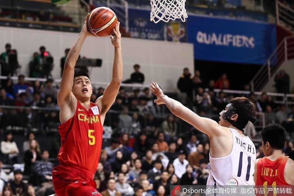 中国男篮红队赛前击掌鼓劲，李楠指导面色严峻地布置战术，身旁的小伙子们眼神坚毅，毫无畏惧之色。