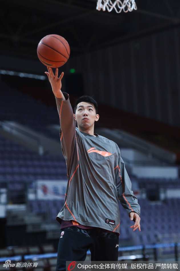 眼神坚毅的阿的江指导双手环抱胸前，神情专注地凝视着球场，仿佛在思考着当晚的排兵布阵。