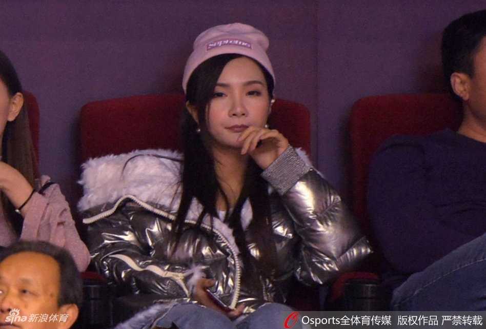 丁彦雨航女友手握应援棒，眼神穿过人群聚焦在赛场上的丁彦雨航身上，满含期待与支持，仿佛在用无声的语言为他打气。