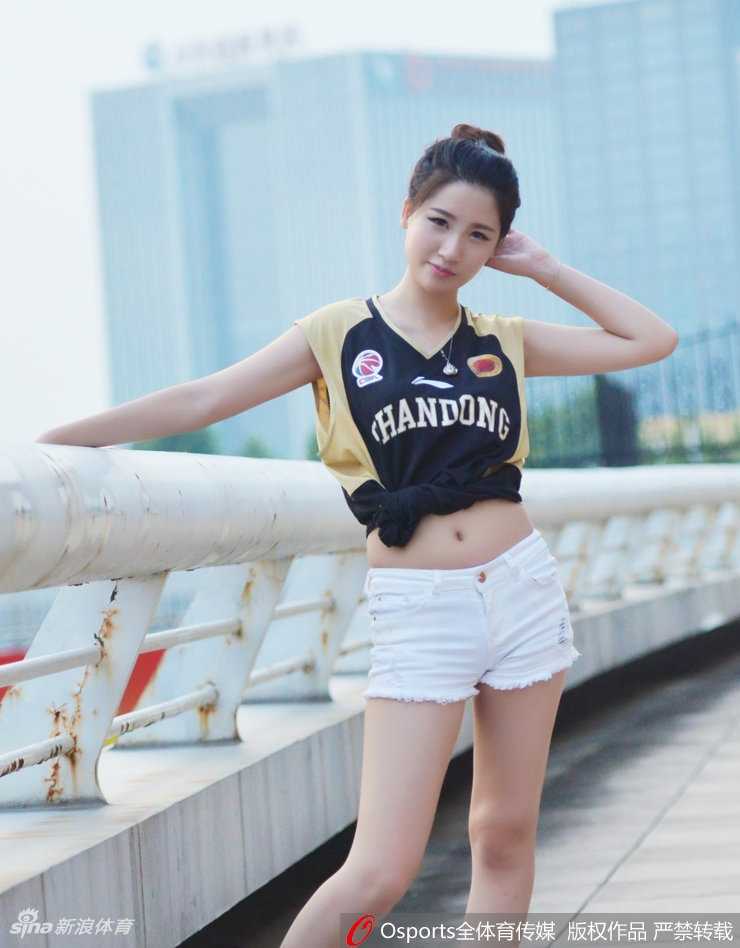 看台上的热情支持者，另一位女球迷转过身来，精致的面容上洋溢着青春的气息。她俏皮地歪着头，单手指向身后的赛场，仿佛在向全世界宣告：这里是山东男篮的荣耀之地，我们与球队并肩作战。